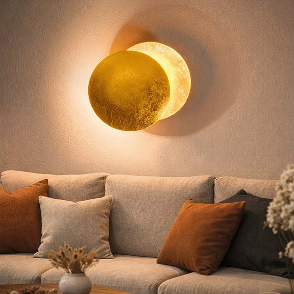 Applique murale éclipse LED laiton au-dessus d'un canapé