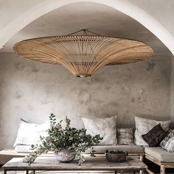 Grand lustre chapeau en rotin au-dessus d'un lit, chambre style japandi