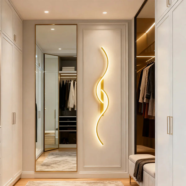 Applique murale LED dorée design en S près d'un dressing